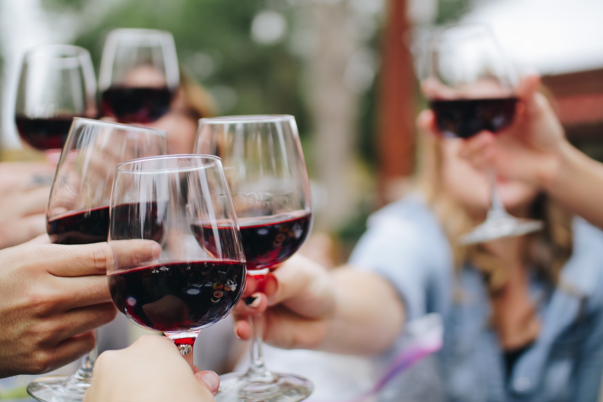 people toasting with glasses of red wine